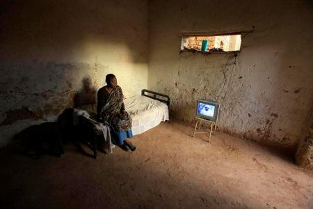 A woman watches television in her house in the outskirts of Sudan's capital, Khartoum April 5, 2010. REUTERS/Zohra Bensemra (SUDAN - Tags: SOCIETY IMAGES OF THE DAY)