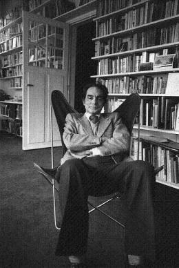 Italo Calvino sentado en una BKF en su biblioteca
